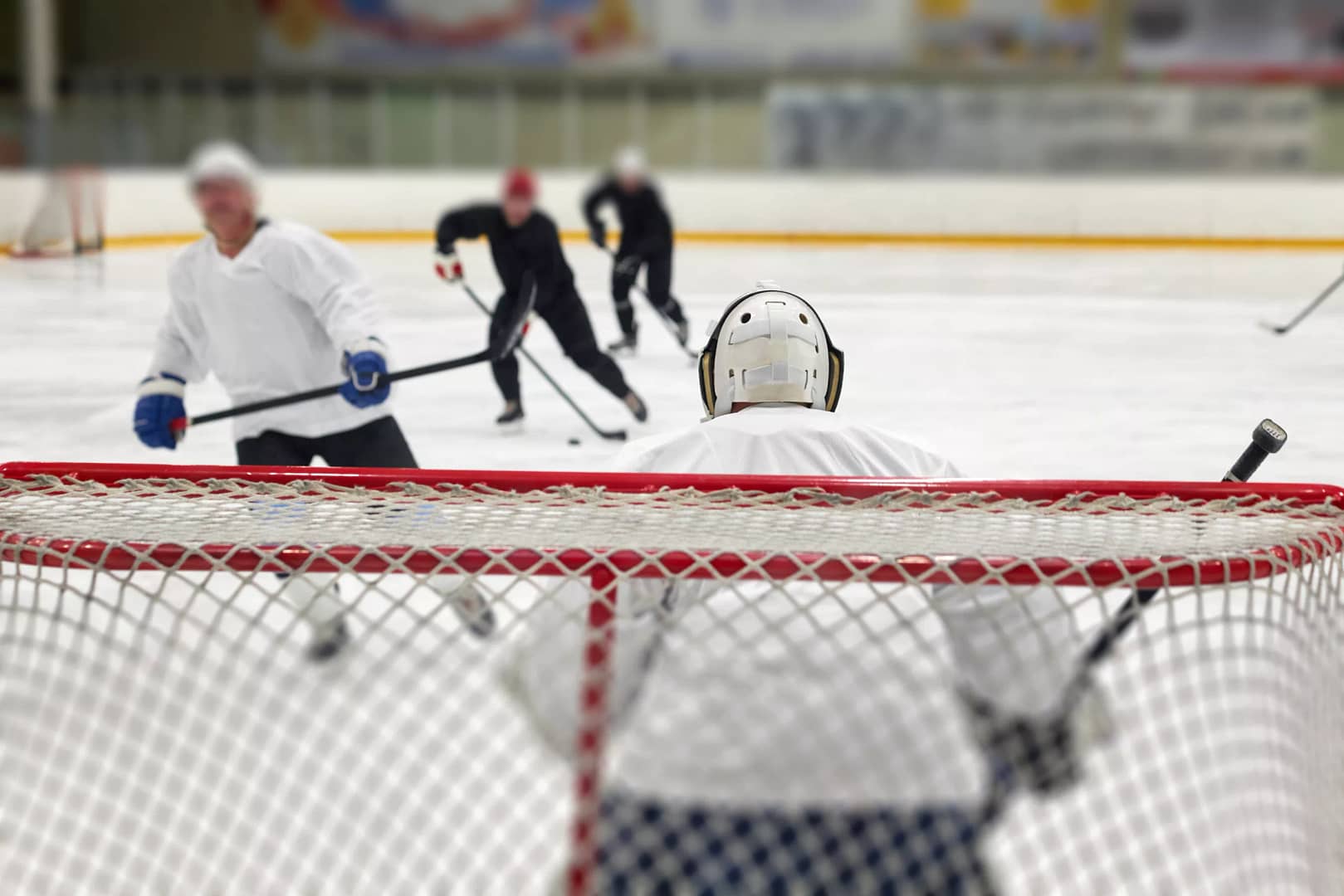 man taking aim for goal on hockey goalie